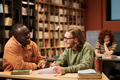 Young Black Man and Man Studying Together in Library - PhotoDune Item for Sale