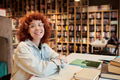 Portrait of Young Woman Smiling While Studying in Library - PhotoDune Item for Sale