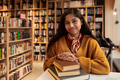 Portrait of Teenager Asian Girl Smiling While Sitting in Library - PhotoDune Item for Sale