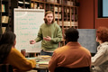 Young Man Teaching Multiethnic People Spanish Language in Library - PhotoDune Item for Sale