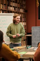 Young Man Teaching English Lesson to Diverse Students in Library - PhotoDune Item for Sale