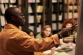 Black Man Explaining Concept to Diverse Group in Library Setting - PhotoDune Item for Sale