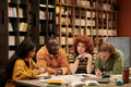 Multiethnic Young People Analyzing Study Materials Together in Library Setting - PhotoDune Item for Sale