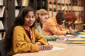 Portrait of Young Asian Woman Smiling While Studying in Library - PhotoDune Item for Sale
