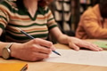 Young Woman Writing on Paper While Studying in Library Setting - PhotoDune Item for Sale