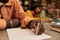 Young Black Man Writing Exam Paper in Library with Focused Students - PhotoDune Item for Sale