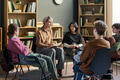 Multiethnic Young People and Adult Woman Participating in Group Therapy - PhotoDune Item for Sale