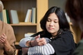 Young Asian Woman Participating in Group Therapy Session with Peers - PhotoDune Item for Sale