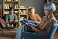 Adult Woman Taking Notes While Leading Group Therapy Discussion - PhotoDune Item for Sale