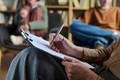 Woman Taking Notes during Group Therapy Session with Diverse People - PhotoDune Item for Sale