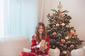 Smiling Girl In Pajamas Beside Christmas Decorated Tree - PhotoDune Item for Sale