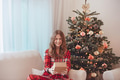 Smiling Girl In Pajamas Beside Christmas Decorated Tree - PhotoDune Item for Sale