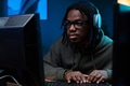 Young Black Man Wearing Headphones Using Computer While Concentrating - PhotoDune Item for Sale