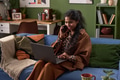 Young South Asian Woman Smiling While Talking on Phone and Using Laptop - PhotoDune Item for Sale