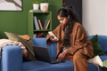 Young South Asian Woman Using Smartphone While Working on Laptop Indoors - PhotoDune Item for Sale