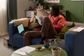 Young Black Man Reviewing Documents While Sitting on Sofa at Home - PhotoDune Item for Sale