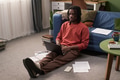 Young Black Man Sitting on Floor Using Laptop for Remote Studying - PhotoDune Item for Sale