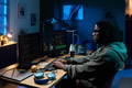 Young Black Man Coding Software on Multiple Computer Monitors at Night - PhotoDune Item for Sale