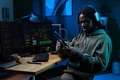 Young Black Man Wearing Headphones Using Tablet at Computer Desk - PhotoDune Item for Sale