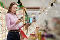 Young Woman Comparing Product Labels While Shopping Indoors - PhotoDune Item for Sale