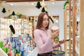 Young Woman Comparing Skincare Products While Shopping in Store - PhotoDune Item for Sale