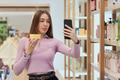 Young Woman Filming Product Review with Smartphone in Store - PhotoDune Item for Sale