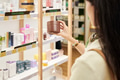 Young Asian Woman Examining Cosmetic Product in Pharmacy Store - PhotoDune Item for Sale