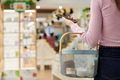 Young Woman Shopping in Store While Using Smartphone - PhotoDune Item for Sale