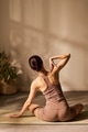 Young Adult Caucasian Woman Practicing Seated Yoga Stretching on Mat Indoors - PhotoDune Item for Sale