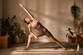 Young Adult Caucasian Woman Performing Extended Side Angle Yoga Pose Indoors - PhotoDune Item for Sale