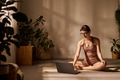 Caucasian Young Adult Woman Sitting Cross Legged Engaging in Virtual Yoga Session - PhotoDune Item for Sale