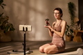 Young Adult Caucasian Woman Demonstrating Dumbbell during Livestream - PhotoDune Item for Sale