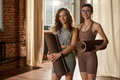 Two Young Adult Caucasian Women Holding Yoga Mats Smiling in Studio - PhotoDune Item for Sale