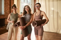Group of Young Adult Women Smiling While Holding Yoga Mats Indoors - PhotoDune Item for Sale