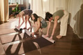 Young Adult Caucasian Women Preparing Yoga Mats in Sunlit Studio Together - PhotoDune Item for Sale