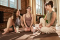 Young Adult Caucasian Women Sitting on Yoga Mats Smiling and Conversing - PhotoDune Item for Sale