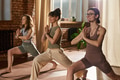 Young Caucasian Women Practicing Yoga Poses during Group Fitness Class Indoors - PhotoDune Item for Sale