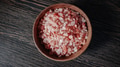 Wooden bowl filled with pink Himalayan salt crystals on dark wooden table - PhotoDune Item for Sale