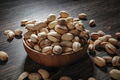 Wooden bowl filled with pistachios on dark wooden table - PhotoDune Item for Sale