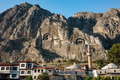 Ancient rock-cut tombs carved in cliff face above Amasya city with traditional Ottoman houses - PhotoDune Item for Sale