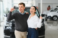 Visiting car dealership. Beautiful couple is holding a key of their new car - PhotoDune Item for Sale
