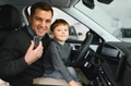 A joyful family sitting inside a new car at a dealership - PhotoDune Item for Sale