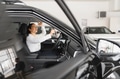Lady in a car salon. Woman buying the car. In a white shirt - PhotoDune Item for Sale