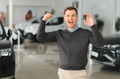 Handsome man customer holding key from auto, buying brand new car in showroom - PhotoDune Item for Sale