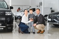 Young happy family enjoying while buying a new car in a showroom - PhotoDune Item for Sale
