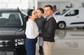 Young happy family enjoying while buying a new car in a showroom - PhotoDune Item for Sale
