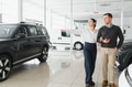 Portrait of a beautiful young couple choosing a new car at a car dealership - PhotoDune Item for Sale