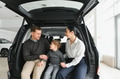 Family in a car dealership. Happy family choosing a new car in a showroom - PhotoDune Item for Sale