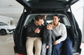 Young happy family enjoying while buying a new car in a showroom - PhotoDune Item for Sale