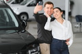 Couple checking new luxury cars at dealership automobile salon - PhotoDune Item for Sale
